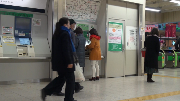 スイカをチャージするA子