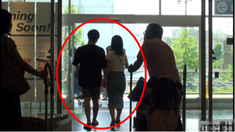 手をつないで店から出る二人