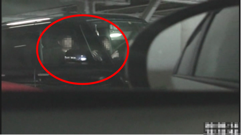 車両で駐車場から出る二人